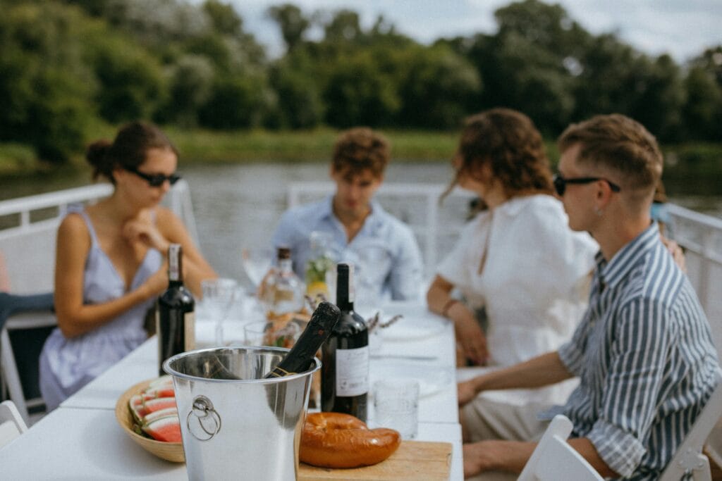 pexels-photo-9750946-9750946 Friends enjoying a relaxing gathering with wine and snacks on a boat during the day.